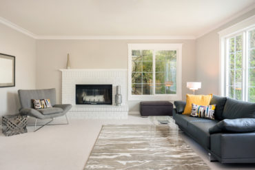 Modern spacious lounge or living room interior with designer furniture and fire place.